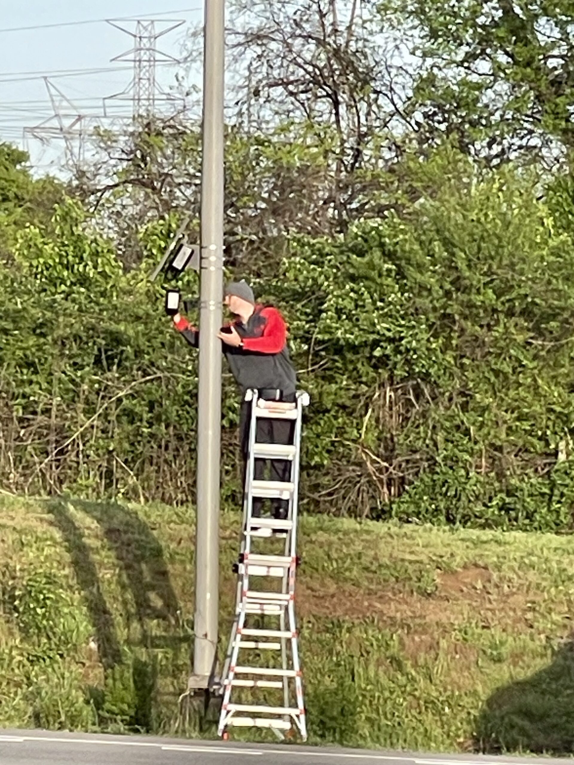 Technician working on a roadside Flock Safety camera unit near the Foothills Mall area of Maryville, Tennessee, April 6, 2026