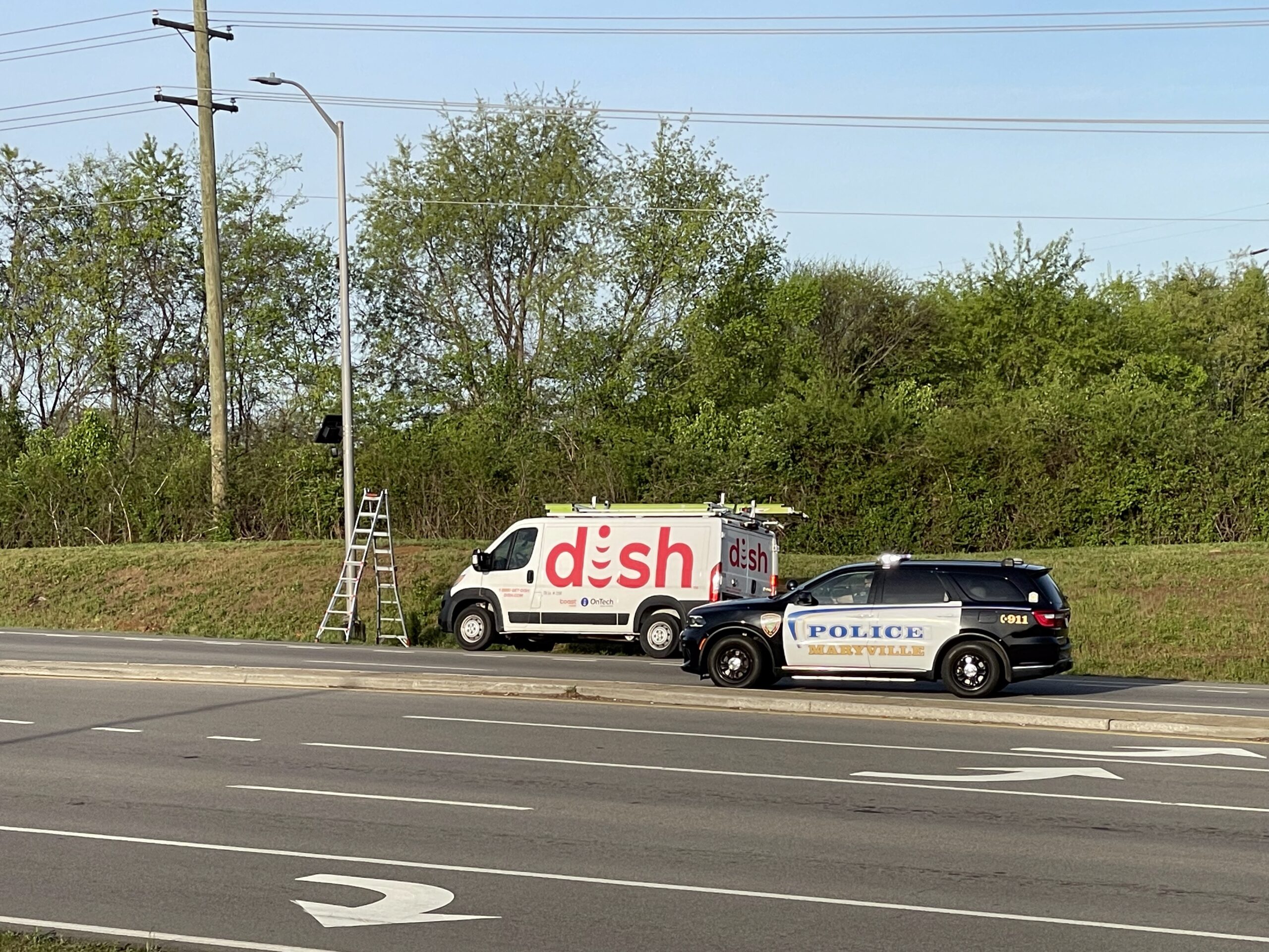 Wide scene showing contractor and police presence at a Maryville, Tennessee Flock Safety camera site, April 6, 2026