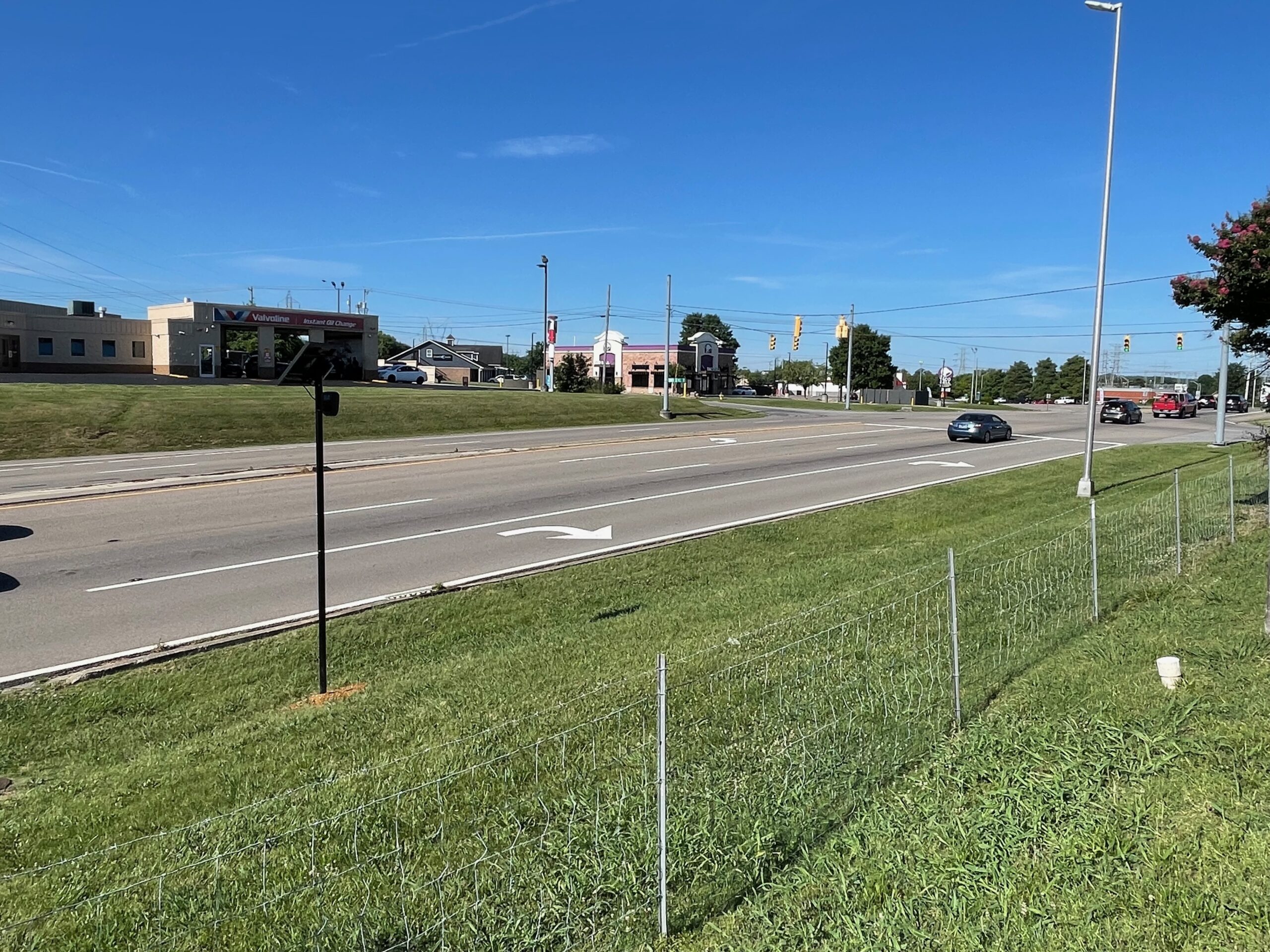 Wide view of a newly installed Flock Safety camera pole near the roadway on Foothills Mall Drive in Maryville, Tennessee